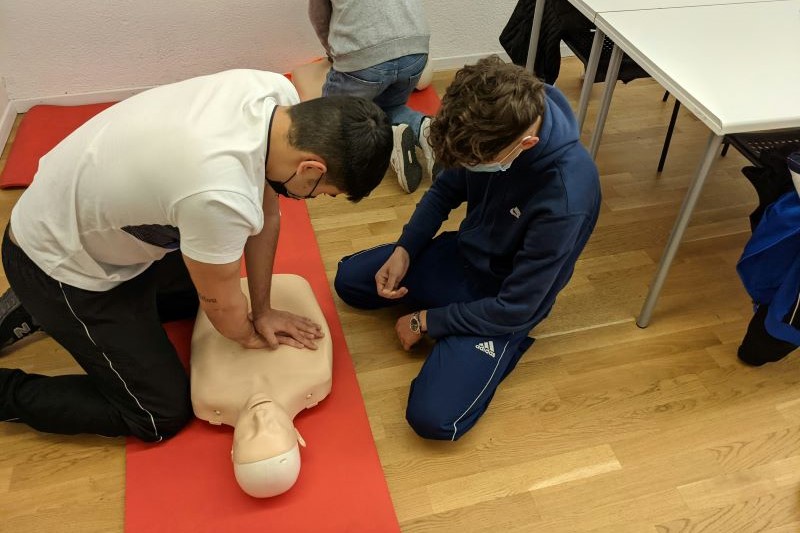 a person teaching a student CPR